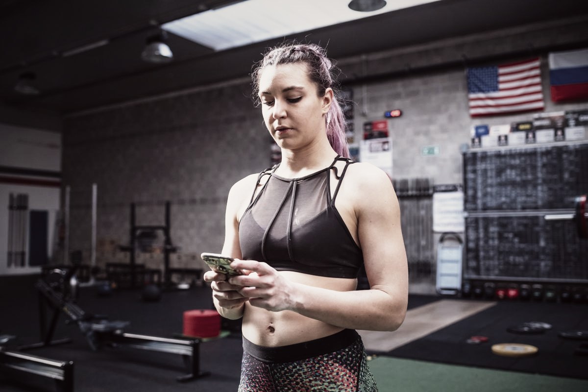 A person sending a text message between sets at the gym