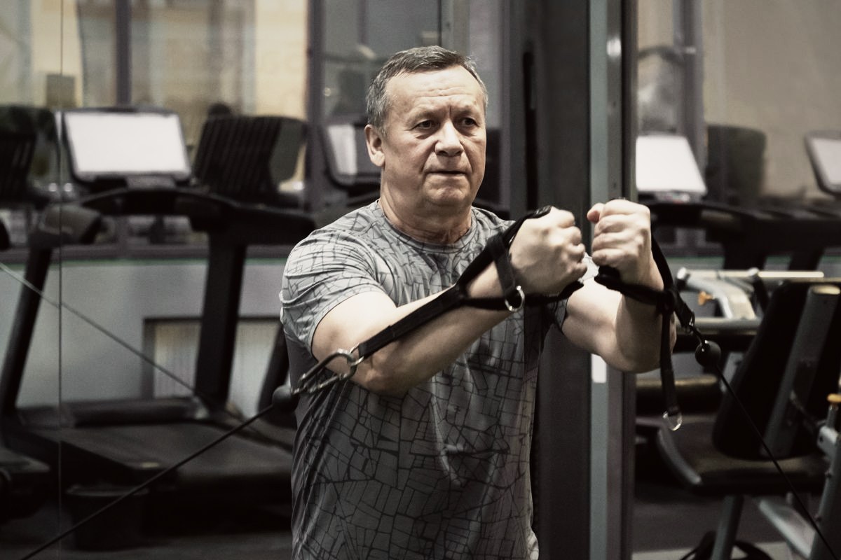 An adult doing a seated cable exercise in a gym