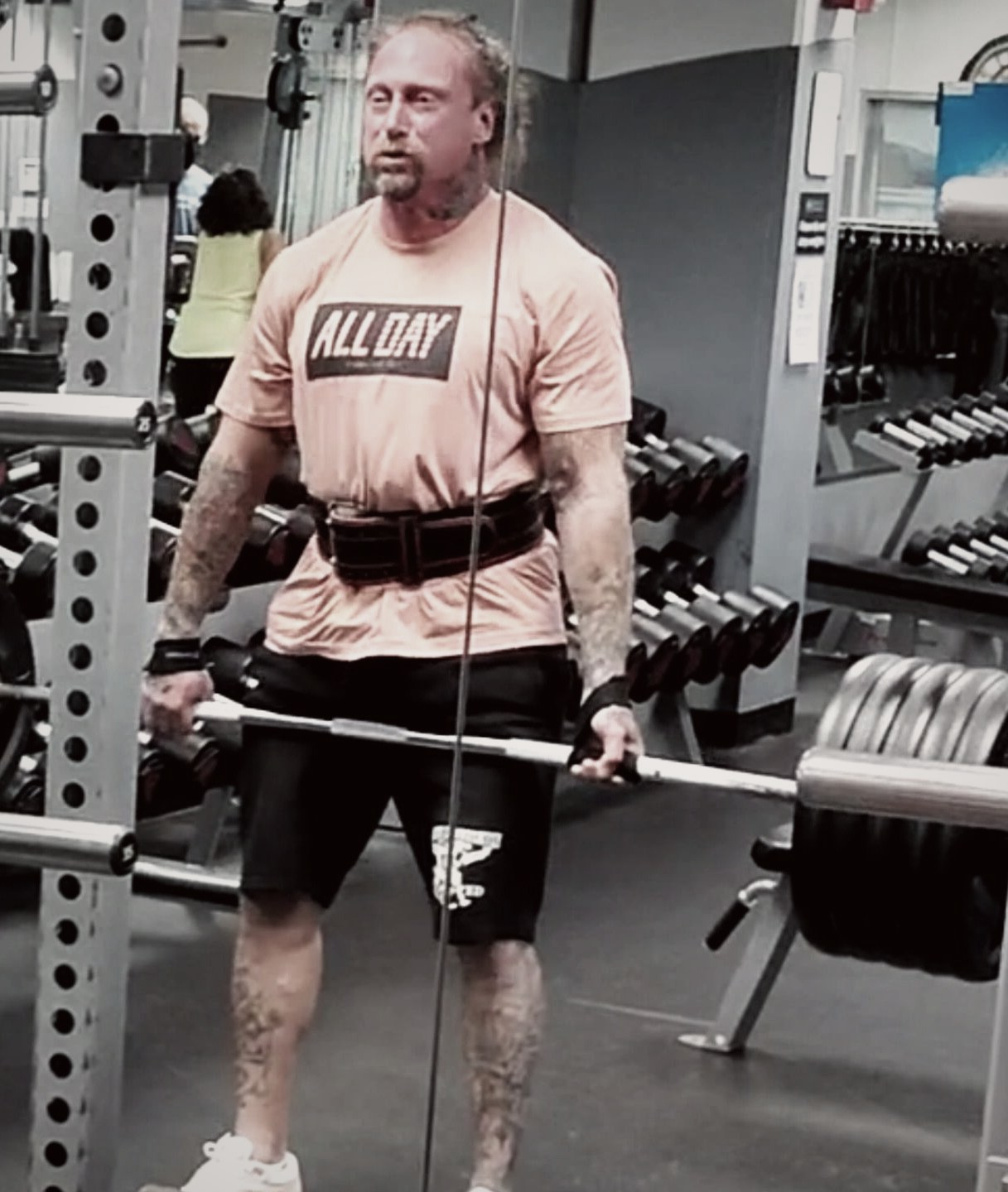 Phillip Walsh in a lifting belt holding a loaded barbell