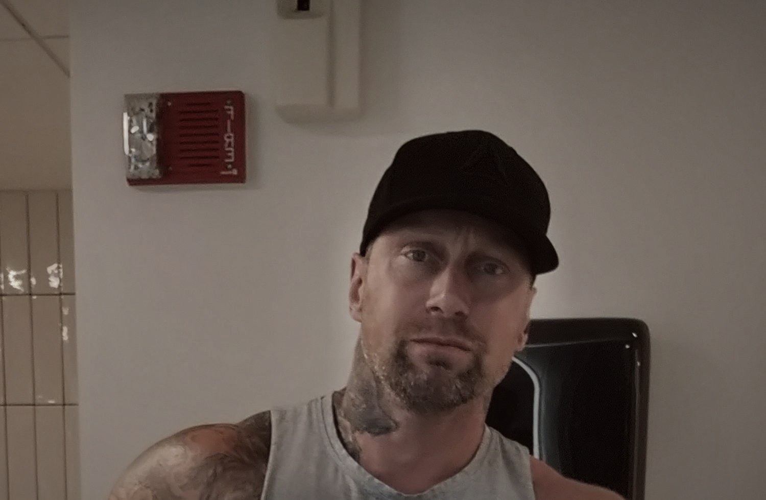 Phillip Walsh in a grey tank and black cap