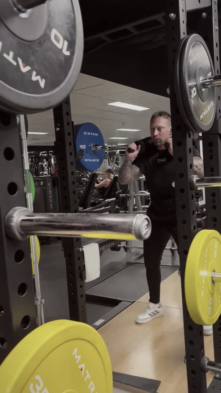Phillip Walsh setting up under a loaded barbell in the rack