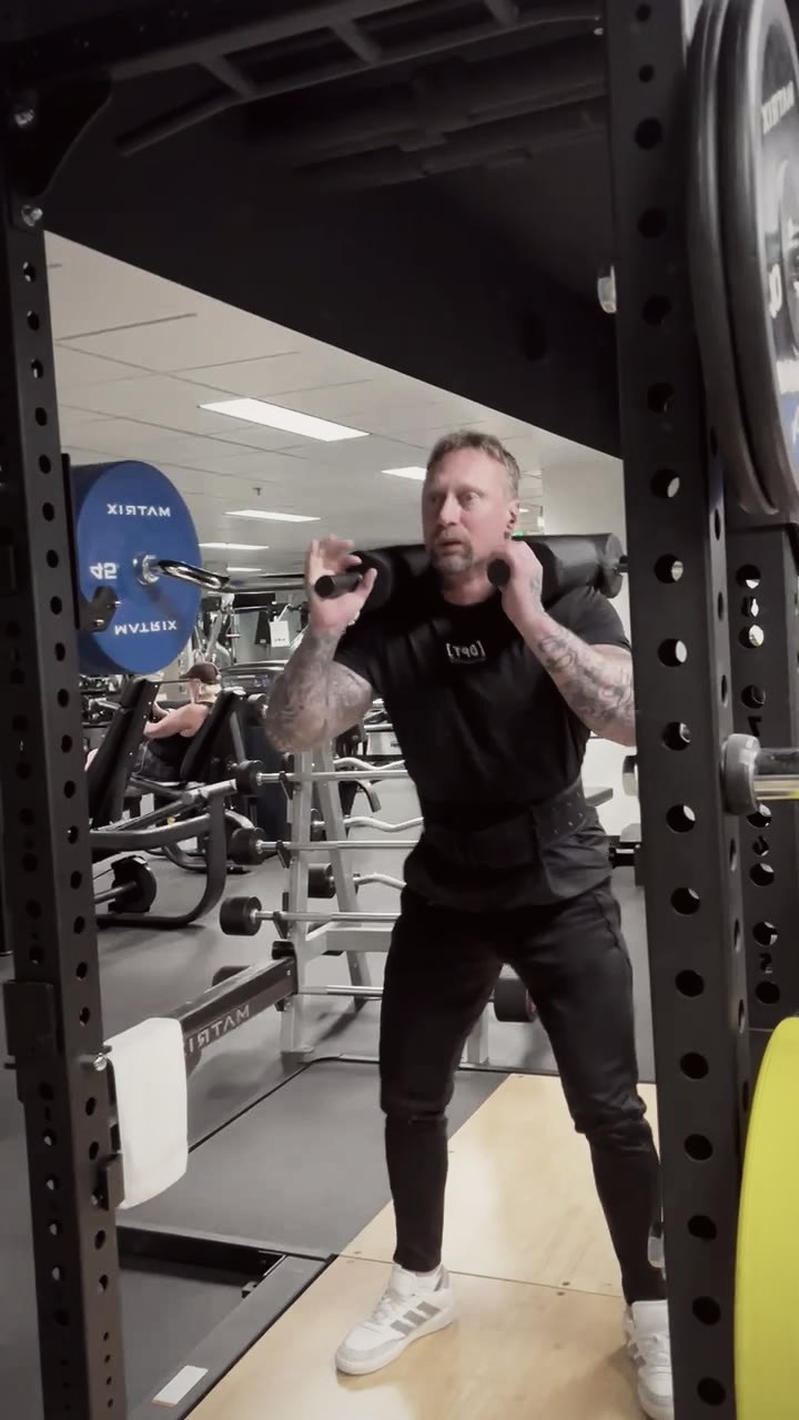 Phillip Walsh lifting a loaded barbell from the rack